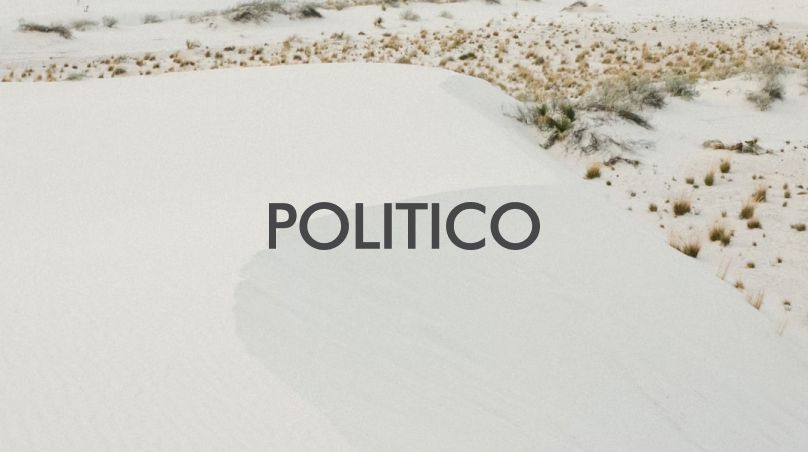 The word 'Politico' written with a sandy desert in the background.